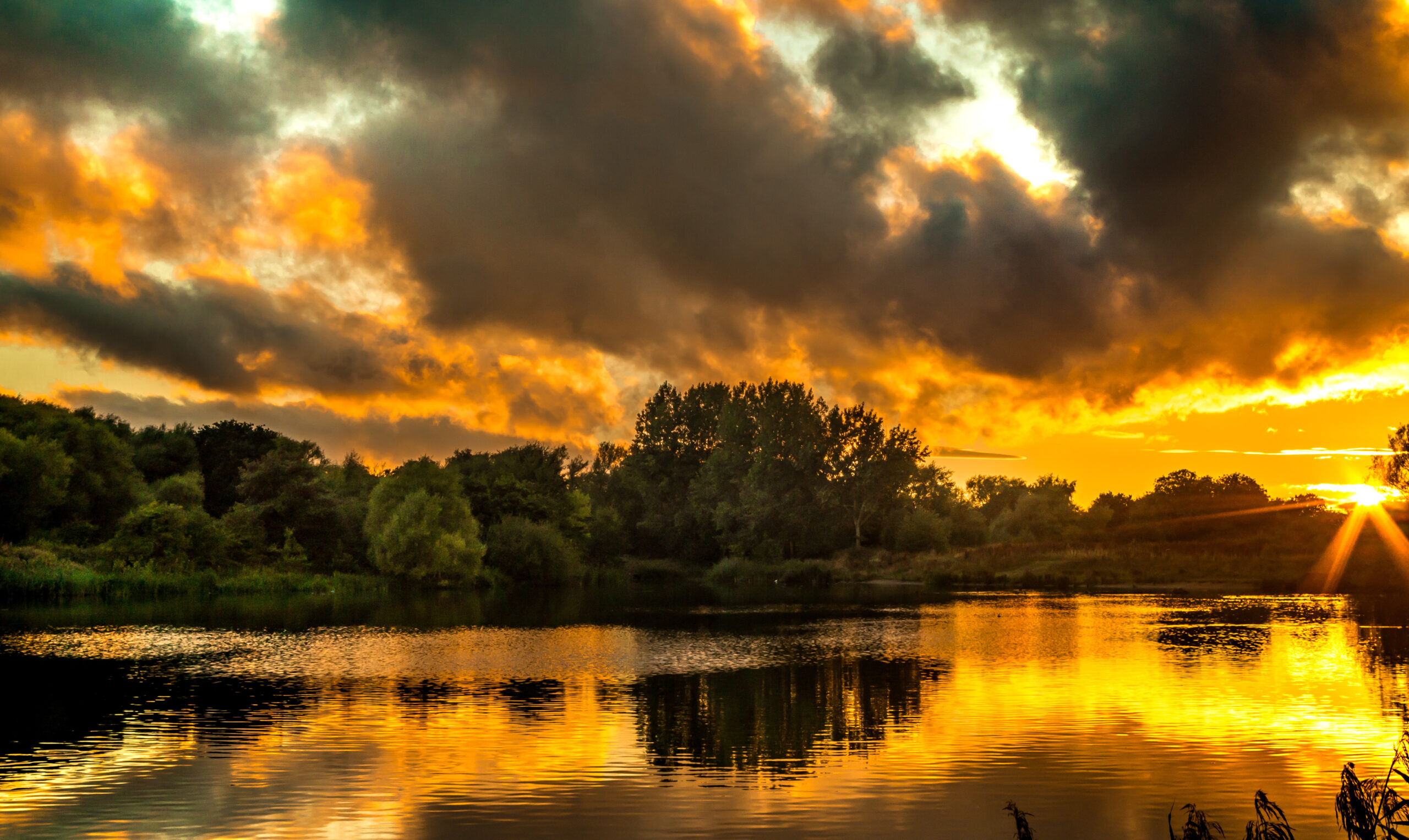 Image of the sunset over a lake in Solihull where we provide Pat Testing