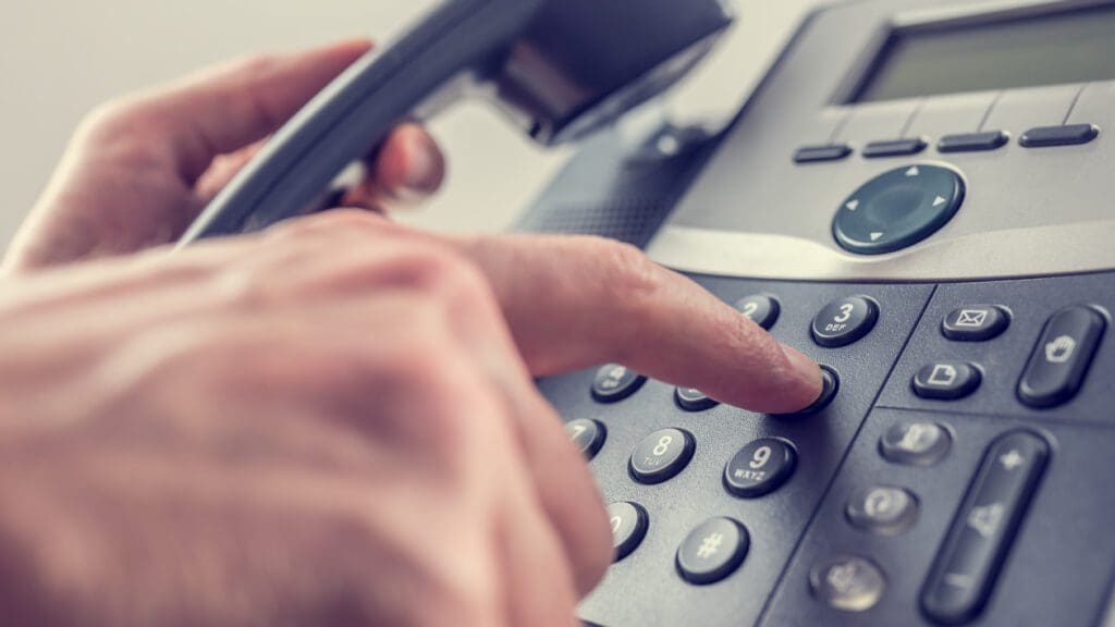 Man dialling out on a landline telephone