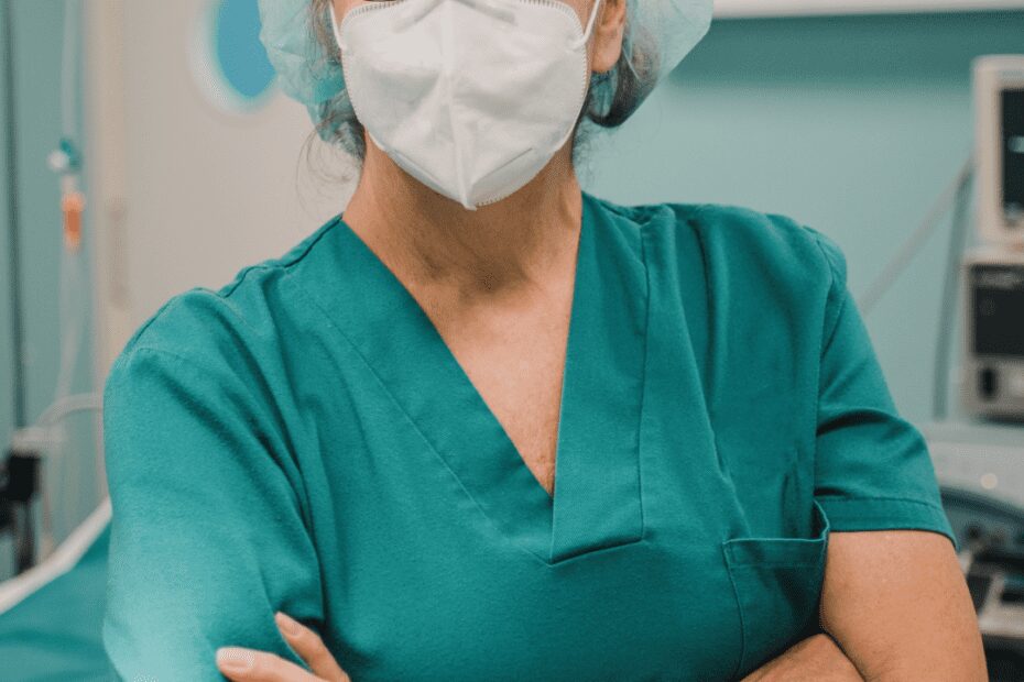 Female nurse wearing her uniform with a face covering mask and hair net