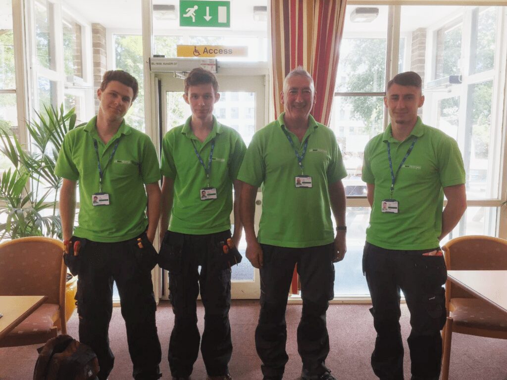 Team photo of 4 members of staff with green polos on