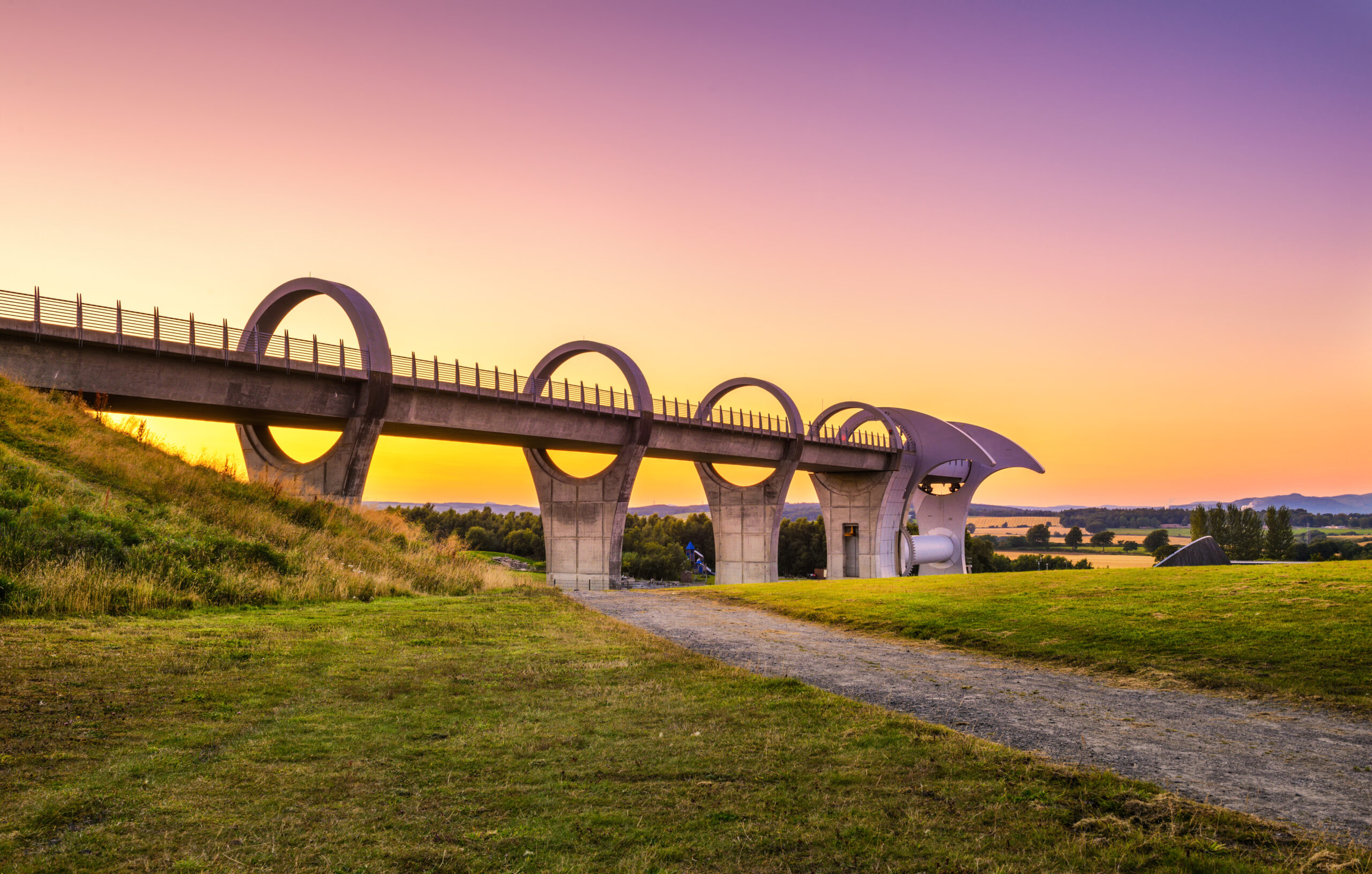 Falkirk Wheel at sunset. Falkirk Wheel is a rotating boat lift in Scotland and connects the Forth and Clyde Canal with the Union Canal.