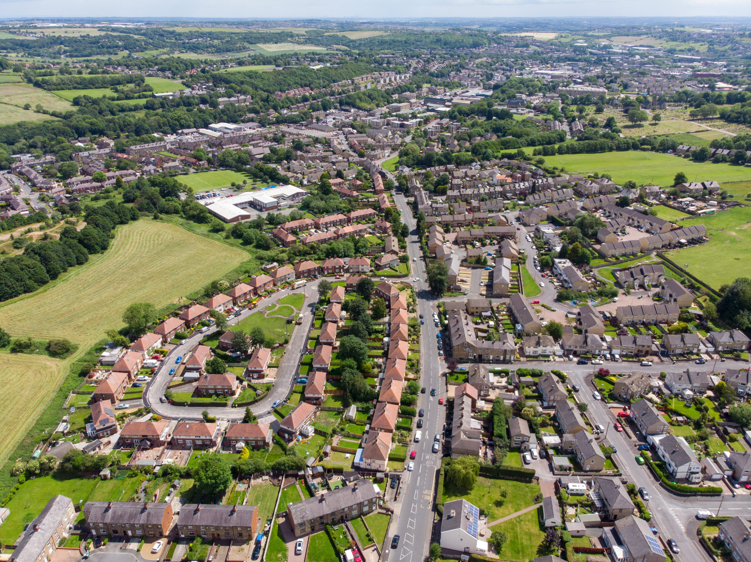 Aerial photo of the town of Batley in Yorkshire UK, showing a typical British housing estates with roads and streets, taken with a drone on a sunny day above the houses.