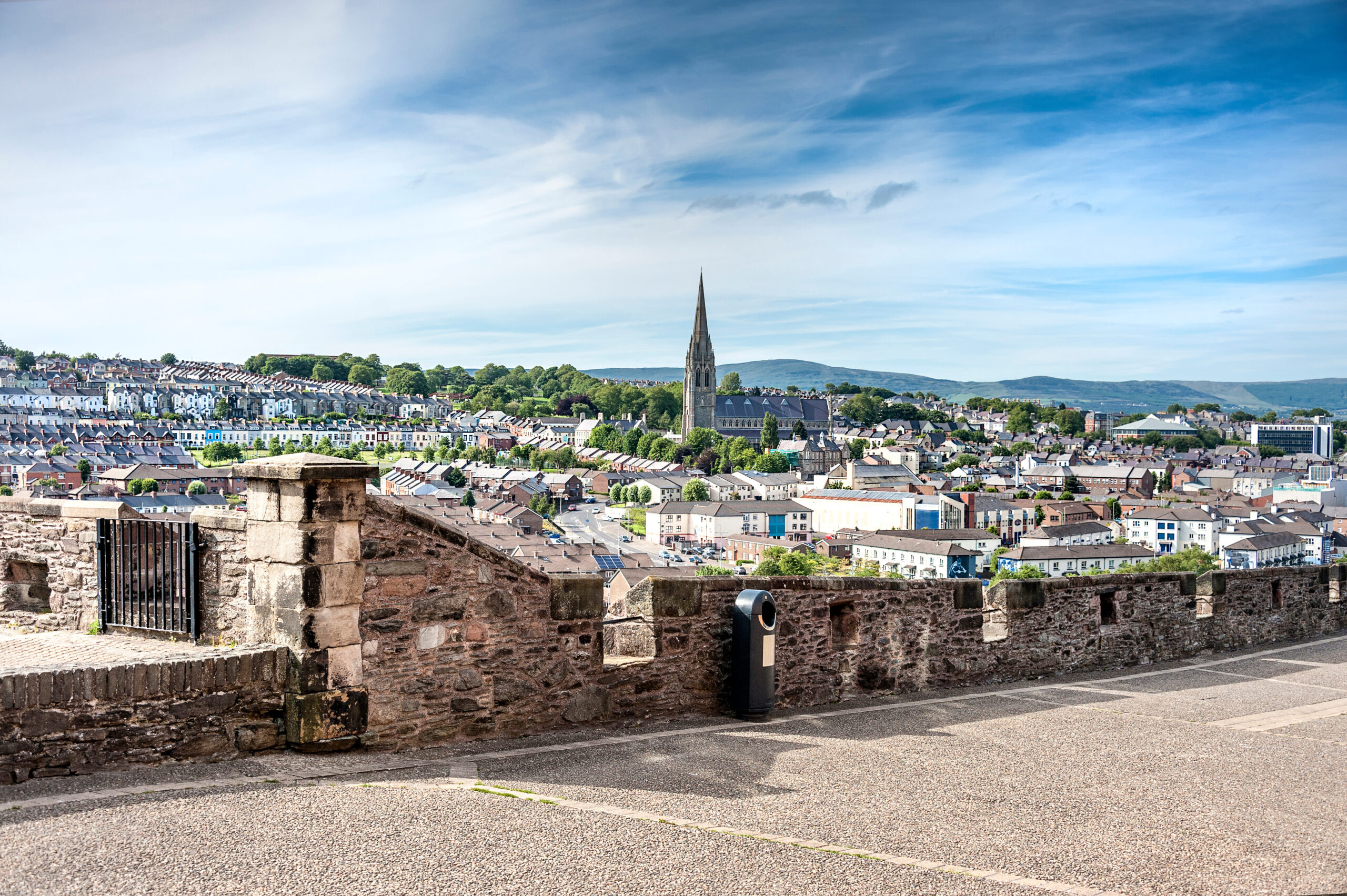 Skyline of Derry with St. Eugene's Cathedral near Free Derry Corner, city wall. horizon and blue sky