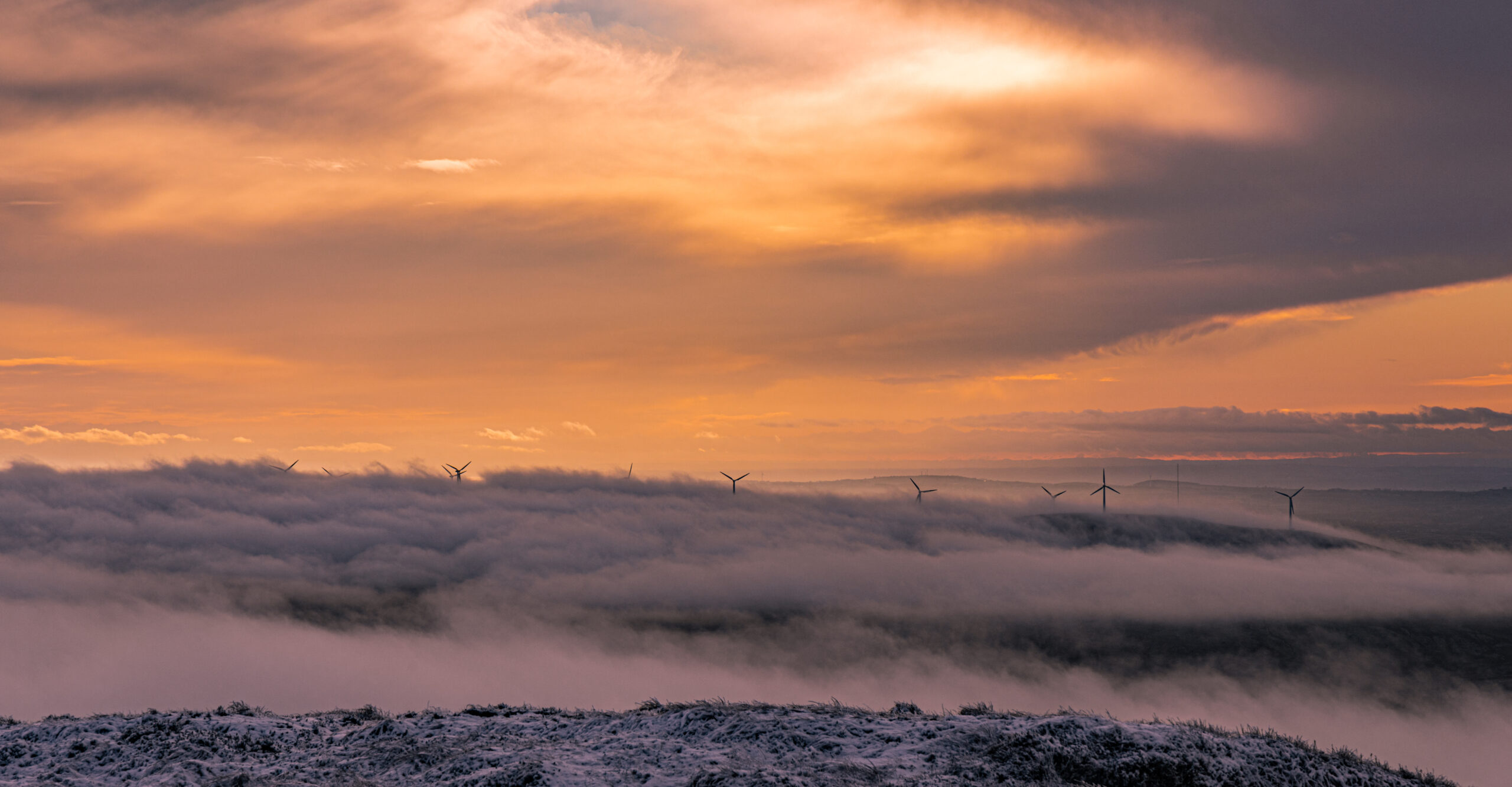 Electric generating windmills appearing through a cloud inversion at sunset, Slieveanorra Mountain, Moyle Way, Glens of Antrim, Causeway Coast and Glens, Northern Ireland